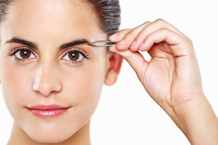 Young Woman Tweezing Her Eyebrows